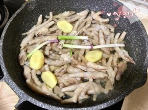 5、鸡爪放入锅里，重新加水没过鸡爪，加入30g料酒，3段葱段，4片姜片。