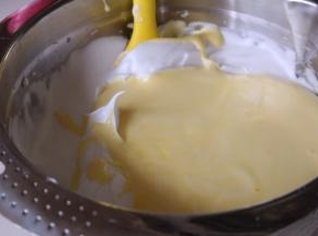 将搅拌均匀的蛋糕糊倒入剩余的蛋白霜中