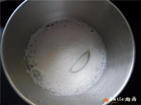 中速搅打到蛋白呈较粗泡沫时，再加入1/3的糖