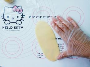 取一个剂子，先轻轻按扁，再用擀面杖以中间为轴，上下轻轻擀薄擀长，长度为一掌。