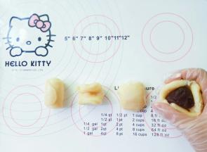 取一个面卷，上下向中间对折，按扁，包入豆沙，虎口收紧收好口。