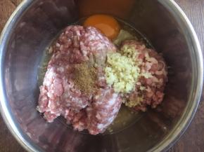 肉馅里放入一个鸡蛋，放入3分之一小勺的十三香，放入3分之一小勺的白胡椒粉，放入2勺的料酒（白糯米酒），放入15g的姜末，朝一个方向搅拌均匀。