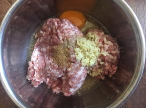 肉馅里放入一个鸡蛋，放入3分之一小勺的十三香，放入3分之一小勺的白胡椒粉，放入2勺的料酒（白糯米酒），放入15g的姜末，朝一个方向搅拌均匀。
