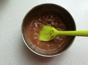 接着把酸奶液倒入费列罗巧克力碎中，搅拌至巧克力融化。