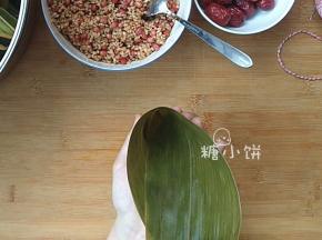 取一片处理好的粽叶，弯成一个锥筒形