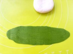 取一份抹茶面团，擀成长条，长度是三角团宽度的三倍左右