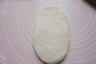 松弛好后将圆形面团上下幹开，幹成椭圆形形状，再送入烤箱发酵功能发酵50分钟。