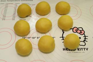 托出面团，轻压排气后平均分成9份，盖上保鲜膜松弛15分钟