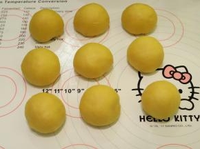 托出面团，轻压排气后平均分成9份，盖上保鲜膜松弛15分钟