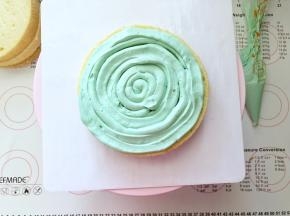 19、取一片蛋糕放在裱花台上，奶酪霜装入裱花袋剪一个小口，画圈方式挤上一层奶酪霜。