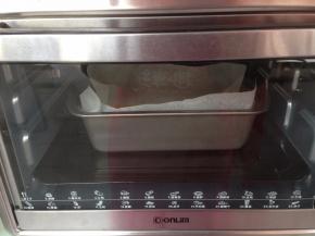 然后倒入380克的吐司模里（模具里面铺一张油纸，方便脱模），继续用烤箱的发酵档发酵50分钟