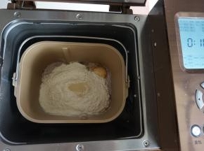 倒入奶粉和面粉，在面粉顶端加入酵母，面包桶放入到东菱1352AE-3C面包机里，选择和面10分钟（不同型号的面包机和面时间和方法不同，时间仅供参考）