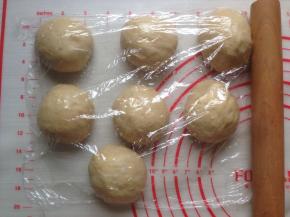 发酵好的面团取出，轻压排气，分成7等份，滚圆，盖上保鲜膜，松驰15分钟