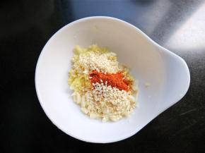 将大蒜，生姜放入碗中，放一勺辣椒粉，一勺芝麻。