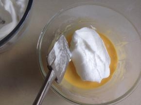 取三分之一已打发好的蛋白霜放入到蛋黄糊里，从底部向上翻拌均匀，不要划圈搅拌