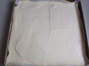 将蛋糕糊倒入已经铺了油纸的正方形烤盘里，用刮板抹平表面，在桌面上震出气泡