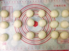 将发酵好的面团取出，轻拍排气，称重后将面团分割成18个均等的小剂子，每个小剂子大约55克左右，滚圆后盖上保鲜膜醒发15分钟左右。