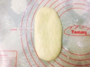 取一个松弛好的面团，擀成椭圆形，用手拍掉两侧气泡。