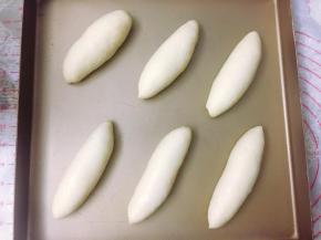 将面包胚放入烤盘，间隔开一定的距离。