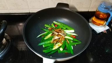 秋葵炒至七成熟，倒入罐头鱼块