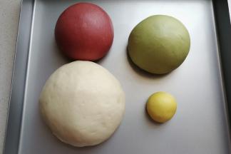 面团发酵好以后，我们把它取出来分别挤压揉搓排气。