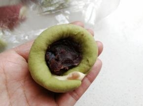 再取适量豆沙馅放入窝形中，然后收口包紧。
