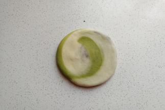 取一份面团，先用手压扁，然后用擀面杖擀成厚薄适中的圆片。