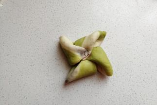 再依次掀起一个角顺着一个方向朝中间折叠过去，一片叠一片压紧。