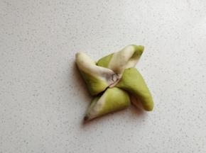 再依次掀起一个角顺着一个方向朝中间折叠过去，一片叠一片压紧。