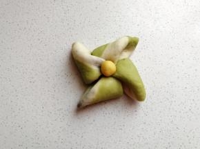 叠好后用筷子在中间按压几下，然后取出先前冷藏的黄色小面团摆上去，这样一个风车面包胚就完成了。
