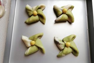 再依次做完所有的风车面包，然后把它们移入烤盘中进行发酵。