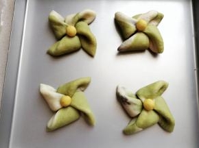 再依次做完所有的风车面包，然后把它们移入烤盘中进行发酵。