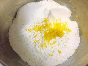 开始制作玛芬蛋糕，先将中筋粉、细砂糖、海盐和无铝泡打粉搅拌均匀，过筛一遍后加入提前刨好的柠檬屑混合均匀。