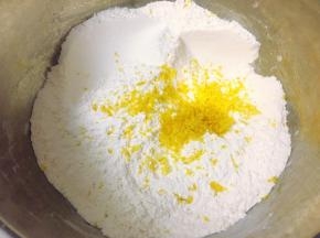 开始制作玛芬蛋糕，先将中筋粉、细砂糖、海盐和无铝泡打粉搅拌均匀，过筛一遍后加入提前刨好的柠檬屑混合均匀。