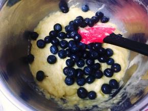 接着倒入之前过筛好的面粉混合物（步骤2），用刮刀翻拌均匀后加入洗净的三分之二的蓝莓，轻轻地拌匀。