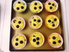 将拌好的面糊用勺子舀入蛋糕模具中，表面放上几颗蓝莓。