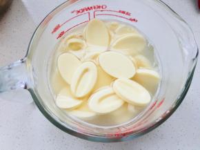 将溶液倒入到白巧克力中，慢慢搅拌知道白巧克力完全融化。加入炼乳。搅拌均匀。