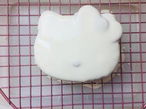 覆盖上KITTY脸的那面蛋糕层，然后淋上镜面淋面。放入冰箱冷藏30分钟后，用黑巧克力勾勒KITTY的眼睛胡子和蝴蝶结。然后用粉色巧克力填充上蝴蝶结。放入冰箱冷藏定型后，方可食用。