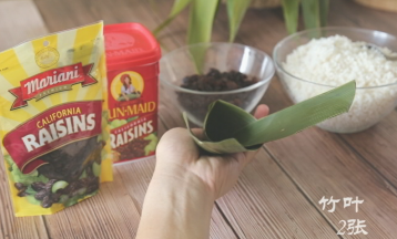 竹叶取2张叠起，去掉头尾，两边往中心收成一个漏斗状，底部要收紧，不然会漏米