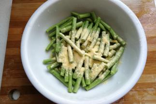 把切好豆角放入大碗中，再加入适量玉米面和少许盐。