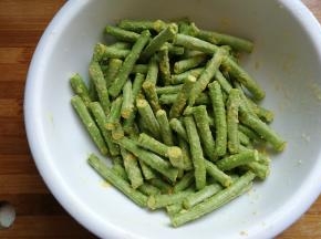 接下来调入一点点食用油，把玉米面和豆角翻拌均匀，让豆角均匀沾满玉米面。