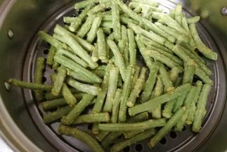 接着把粘好玉米面的豆角放入蒸锅中，冷水上锅水开后蒸五分钟即好。