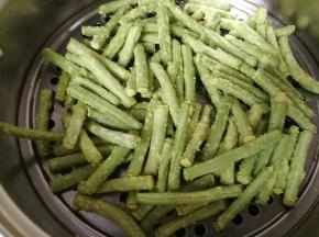 接着把粘好玉米面的豆角放入蒸锅中，冷水上锅水开后蒸五分钟即好。