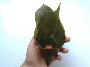 折成漏斗状，先放进一颗红枣，防止漏米。