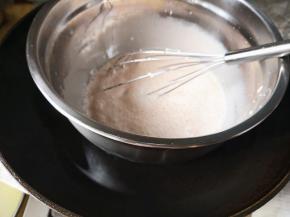 4.	再加入棉花糖35克，把盆放入热水中，搅拌至棉花糖融化，