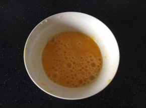 将鸡蛋打散，倒入1小勺的姜汁，搅匀。