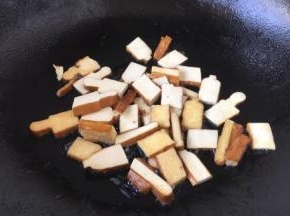 用少许油将香干两面煎一下，煎至两面稍稍有金黄色，盛出备用。