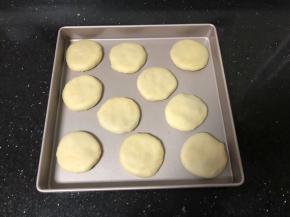 14、收口向下放在烤盘上，用手摁扁，刷上一层薄薄的蛋黄液。