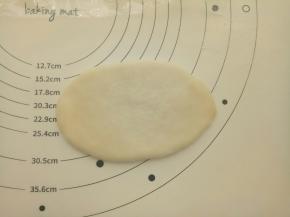 再擀成牛舌形。卷起来。