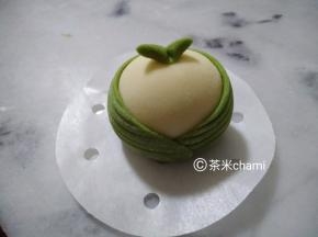 小绿面团搓细，往中间一压，贴在白馒头上。